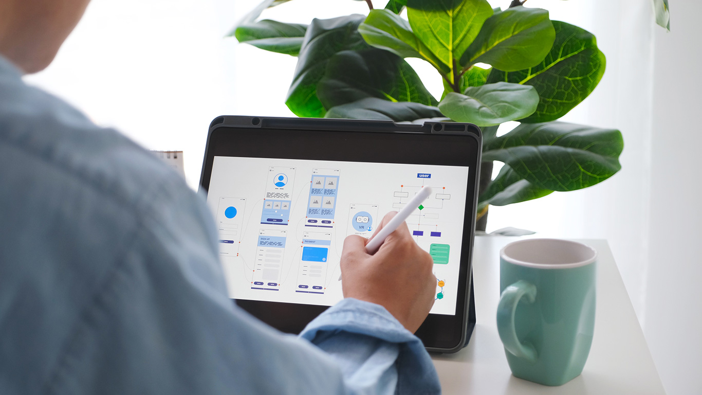 man-hand-holding-digital-tablet-with-mobile-app-development-prototype-while-working-home